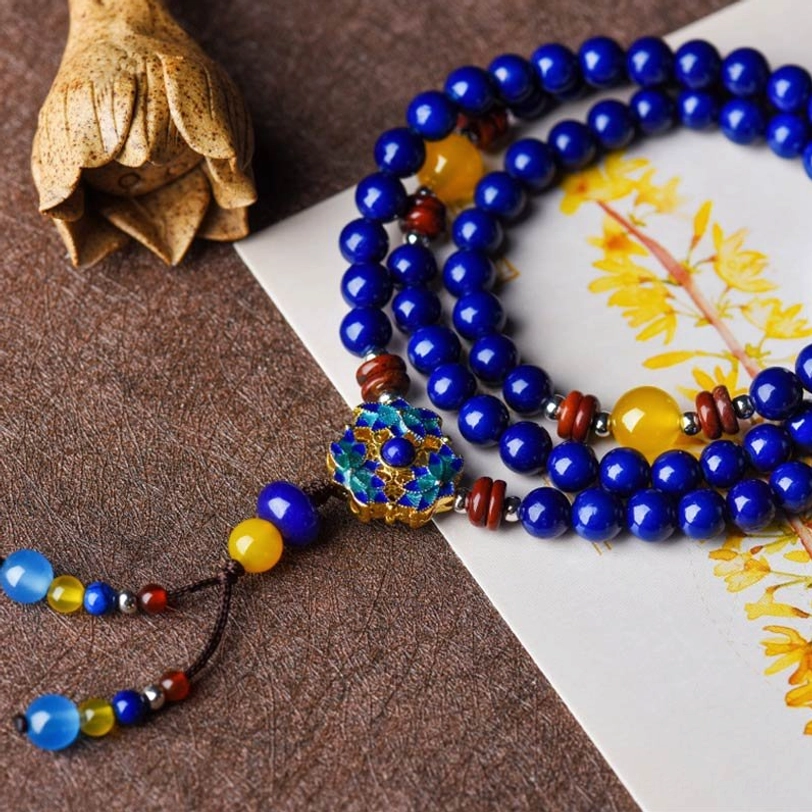 Multi-layer Lapis Lazuli Yellow Agate spiritual bracelet on floral background, showing enamel clasp and decorative tassel