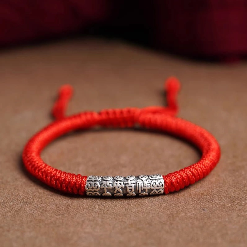 Handmade Tibetan bracelet with red cord and sterling silver charm, featuring adjustable fit for wrist sizes 5.5-7.9 inches