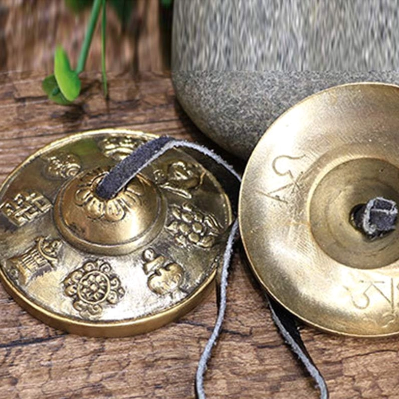 Handmade tibetan tingsha cymbals showing traditional craftsmanship with mantra engravings close-up detail
