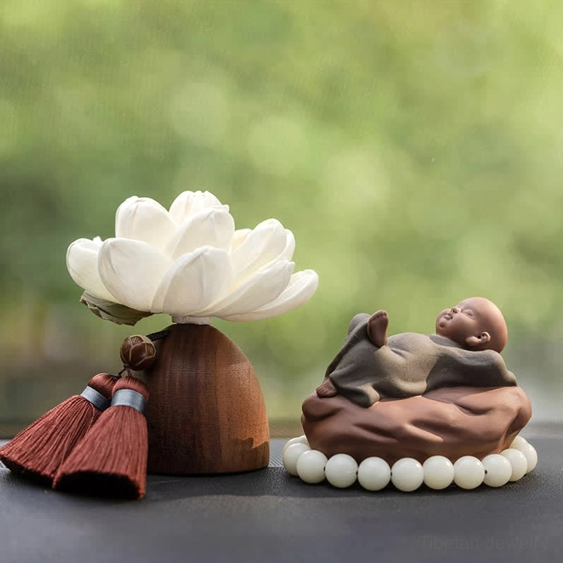 Happy smiling Buddha reclining pose with white lotus flower and brown wooden base, aromatherapy decor set