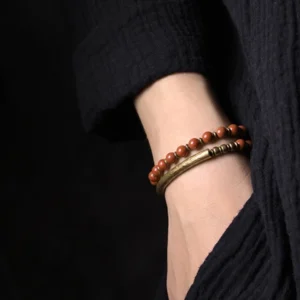 Red stone beads with copper cuff bracelet worn on wrist - side view close-up