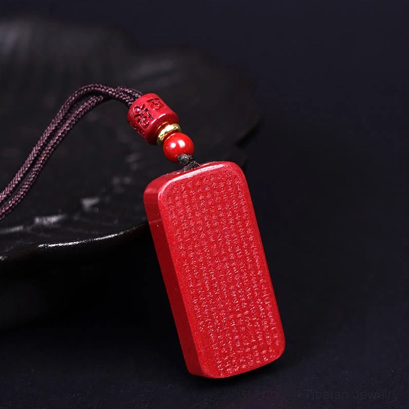 Tibetan Heart Sutra cinnabar necklace side profile showing carved text details and traditional woven cord