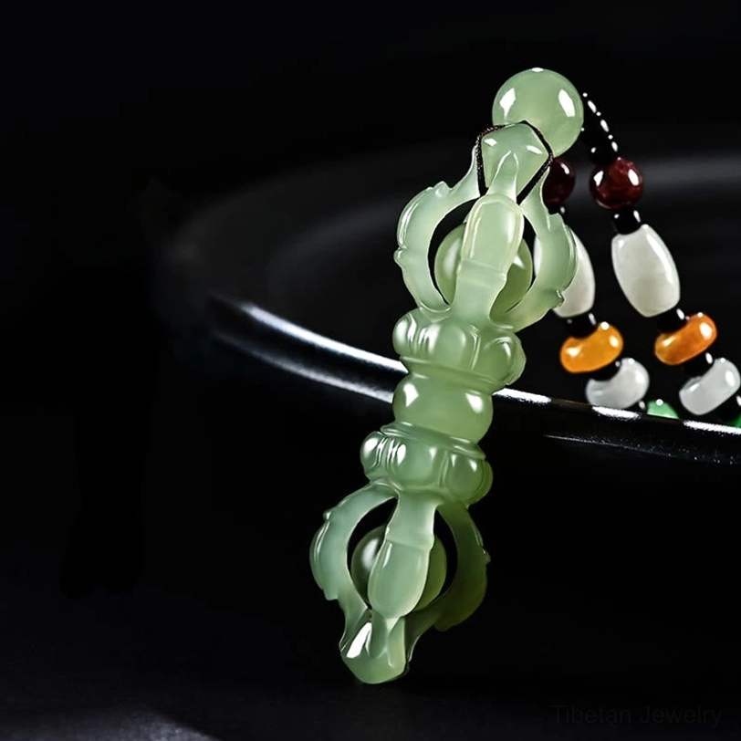 Hetian Jade Dorje Vajra pendant in translucent cyan with smooth polished finish and hollow Vajra carving, black tray background