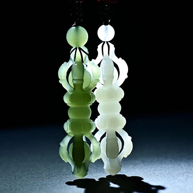 Two translucent Hetian Jade Dorje Vajra necklace pendants side by side, symmetrical design close-up view