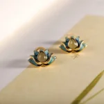 Hetian cyan jade lotus stud earrings pair with gold plating displayed on vintage stationery background, showing delicate lotus flower design