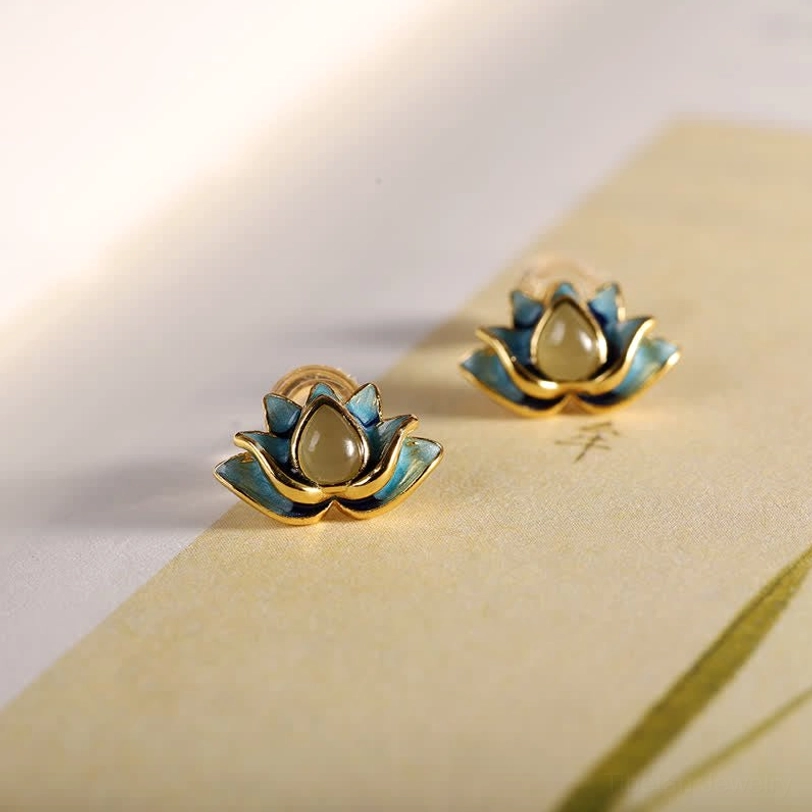 Hetian cyan jade lotus stud earrings pair with gold plating displayed on vintage stationery background, showing delicate lotus flower design