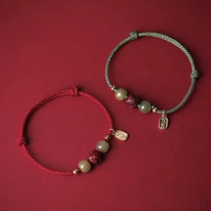 Two matching Hetian jade lucky bracelets in red and cyan rope styles with cinnabar lotus beads