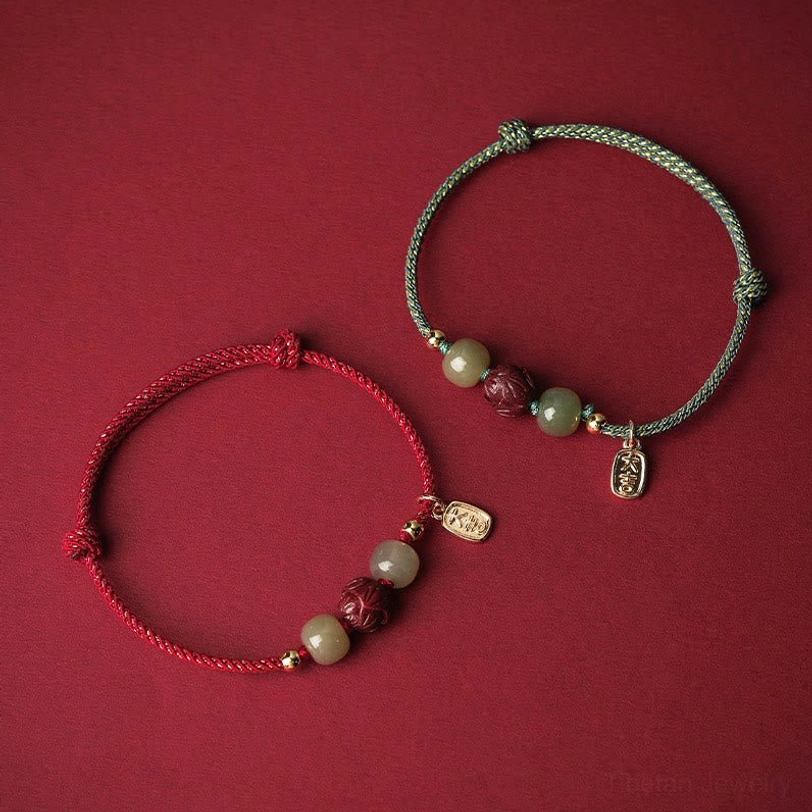 Two matching Hetian jade lucky bracelets in red and cyan rope styles with cinnabar lotus beads