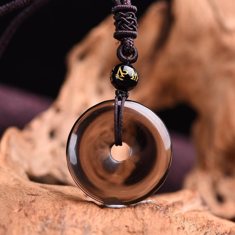 Ice obsidian peace buckle necklace front view with translucent brown stone and Sanskrit decorated bead
