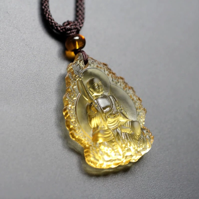 Ivory Ksitigarbha Buddha Liuli crystal pendant with irregular flame frame, carved Bodhisattva relief detail, dark brown braided cord with amber bead accent