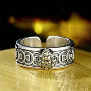 Tibetan Yellow Jambhala adjustable ring with Buddha head and copper coin engravings, front view on wooden table