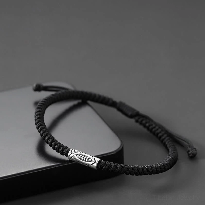 Tibetan style koi fish bracelet on black matte tray showing adjustable string design
