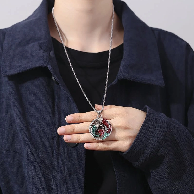 Koi fish necklace worn on body, delicate silver chain pendant displayed over black casual clothing