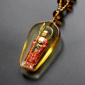 Amber Ksitigarbha Buddha Liuli crystal necklace with standing bodhisattva pendant and brown beaded chain, close-up oblique view