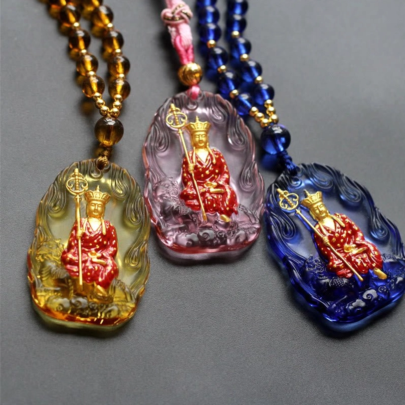 Three Ksitigarbha Buddha Liuli crystal amulet pendants in amber, lavender, and sapphire blue with seated bodhisattva designs and matching beaded chains