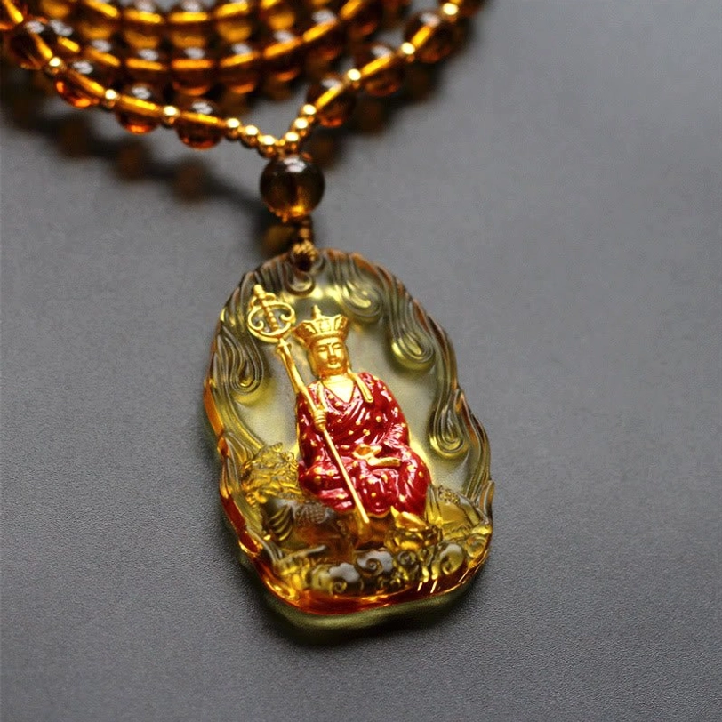 Yellow Ksitigarbha Buddha Liuli crystal pendant with flame border, seated bodhisattva, and brown-yellow beaded chain detail