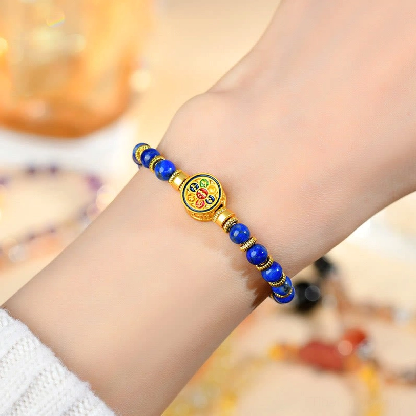 Lapis lazuli Om Mani Padme Hum bracelet worn on wrist showing gold hardware and sacred charm detail