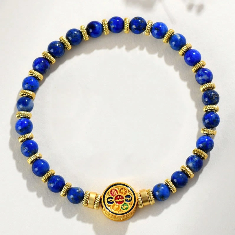 Lapis lazuli elastic stretch bracelet with round blue stone beads and gold ring spacers on white background