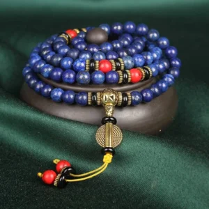 Lapis lazuli tibetan mala bracelet 108 beads top view on wooden display with red turquoise accents