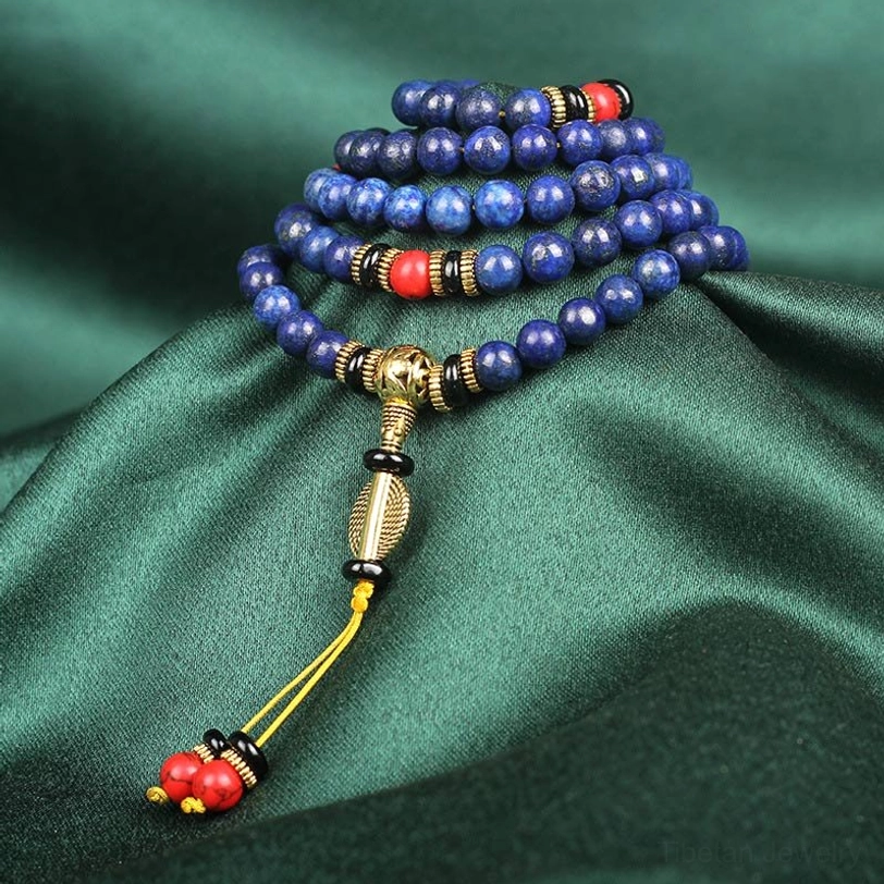 Coiled lapis lazuli mala bracelet side angle displaying stacked blue stone beads with brass spacers and red accents