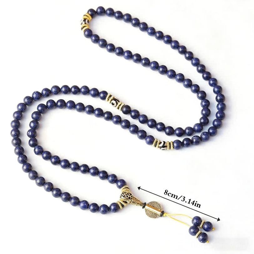 Slanted view of 108-bead lapis lazuli mala necklace with 8mm bead size measurement and gold metal accents on light background