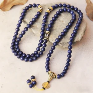 Angled overhead shot of lapis lazuli Tibetan mala showing vintage gold metal accents and beaded tassel detail