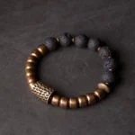 Lava rock and brass healing bracelet with etched metal spacer, flat lay top-down view