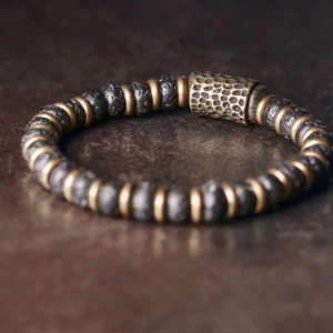 Close-up side view of lava rock beads with hand-hammered copper barrel focal bead and brass spacers