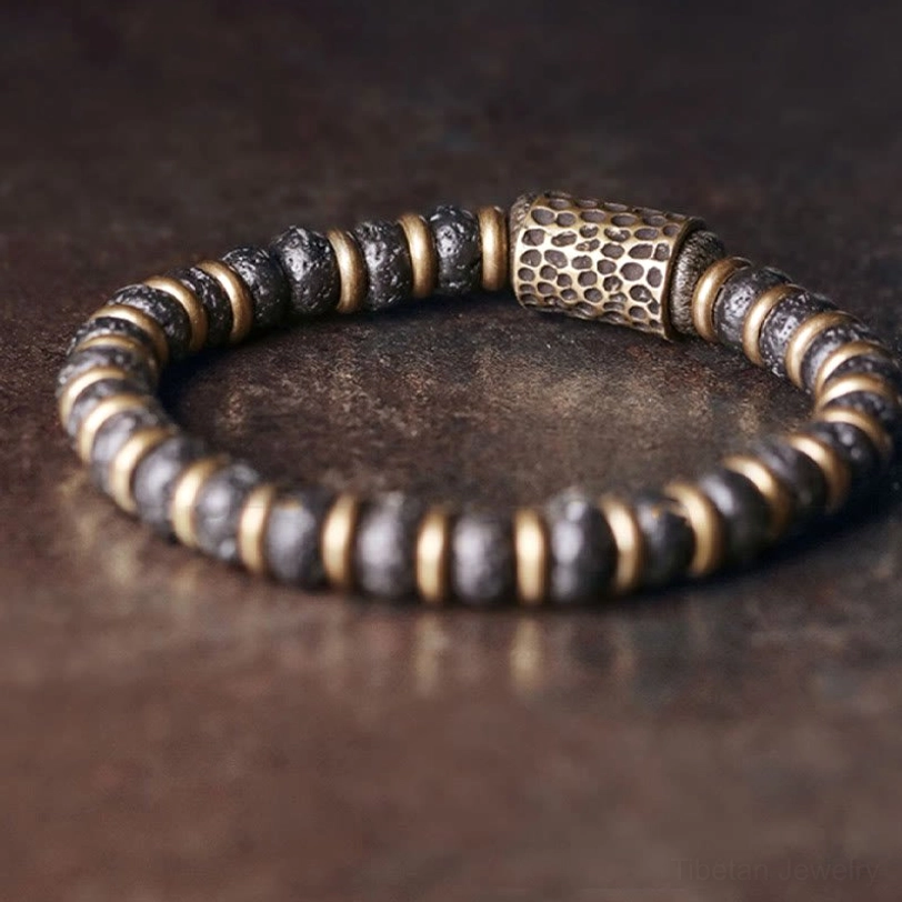 Close-up side view of lava rock beads with hand-hammered copper barrel focal bead and brass spacers