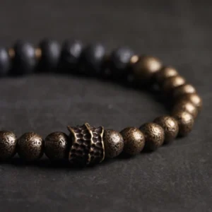 Close-up detail of lava rock copper bracelet showing porous black stone beads and ornate bronze metal connector
