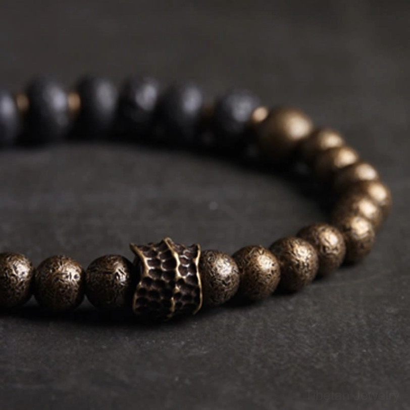 Close-up detail of lava rock copper bracelet showing porous black stone beads and ornate bronze metal connector