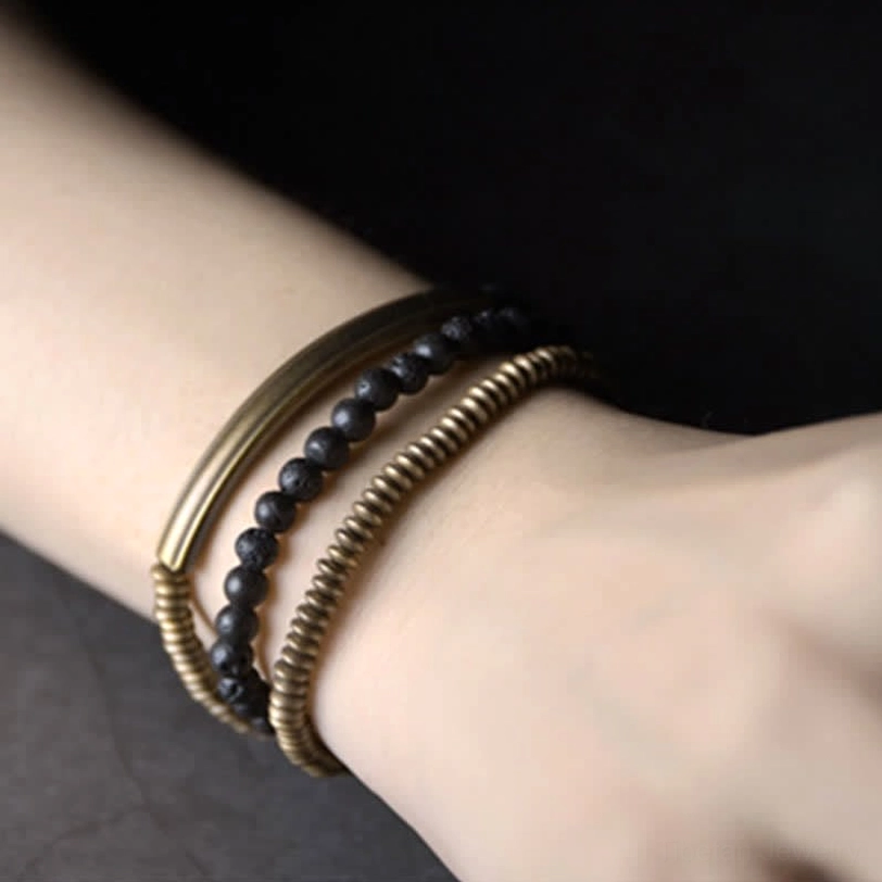 Fitted lava rock and copper healing bracelet worn on wrist showing layered metal coil design
