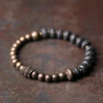 Lava rock copper beaded bracelet overhead flat lay view with dark lava stone beads and bronze metal spacer accents