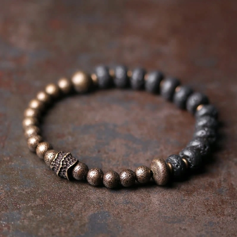 Lava rock copper beaded bracelet overhead flat lay view with dark lava stone beads and bronze metal spacer accents