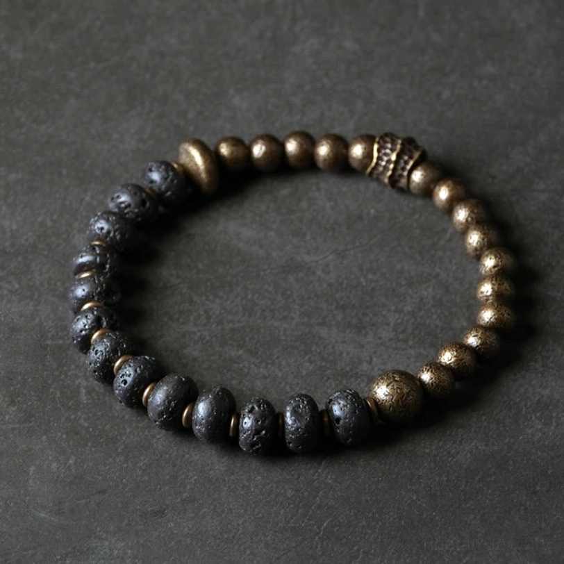 Full circle top-down view of lava rock copper bracelet with carved metal spacer bead and porous stone beads