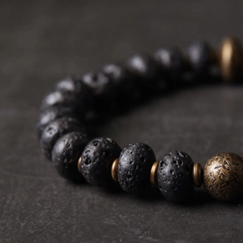 Side view detail of lava rock copper bracelet displaying textured porous lava beads with bronze spacer accents