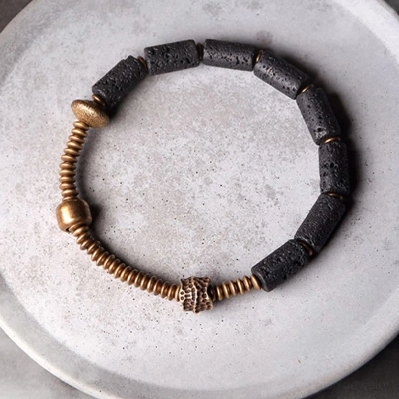 Lava rock copper beaded bracelet arranged on ceramic plate showing all beads and metal accents from overhead