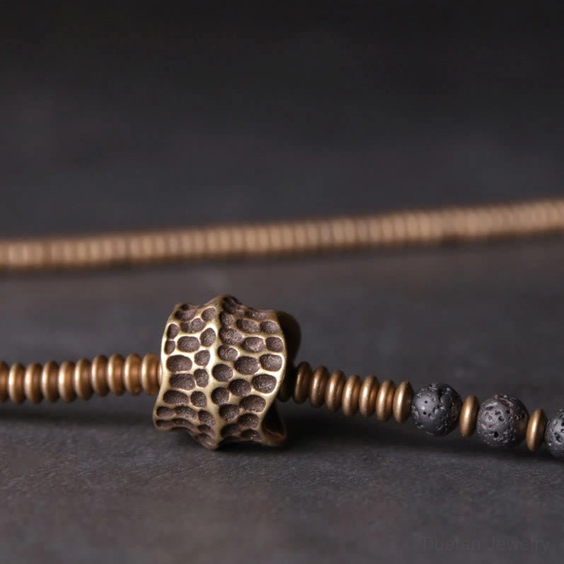 Single strand lava rock healing bracelet with textured brass spacer and coiled metal accents