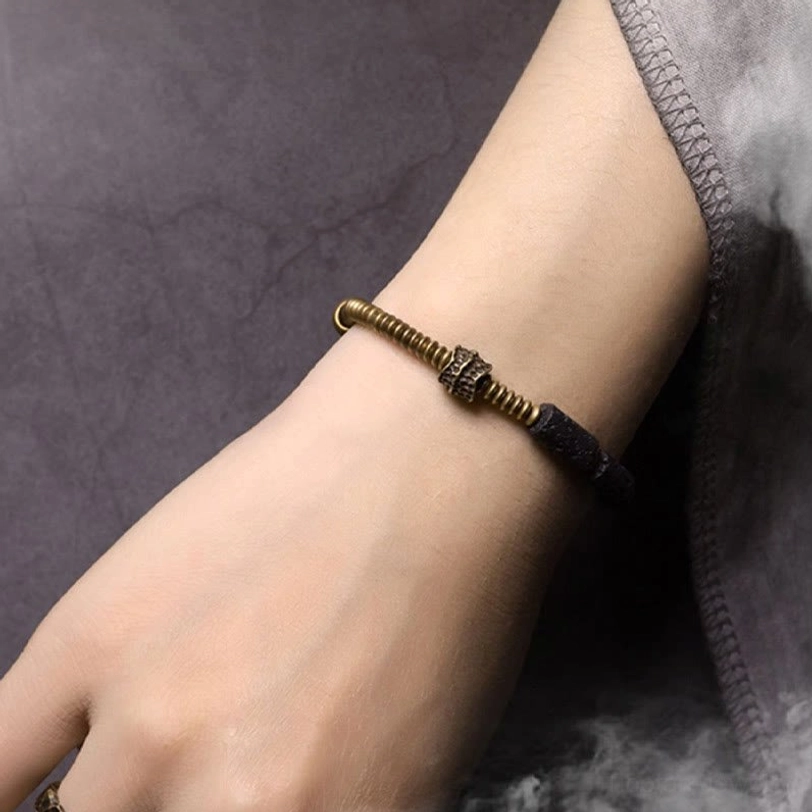 Lava rock copper bracelet worn on adult wrist showing comfortable fit and styling on grey fabric background