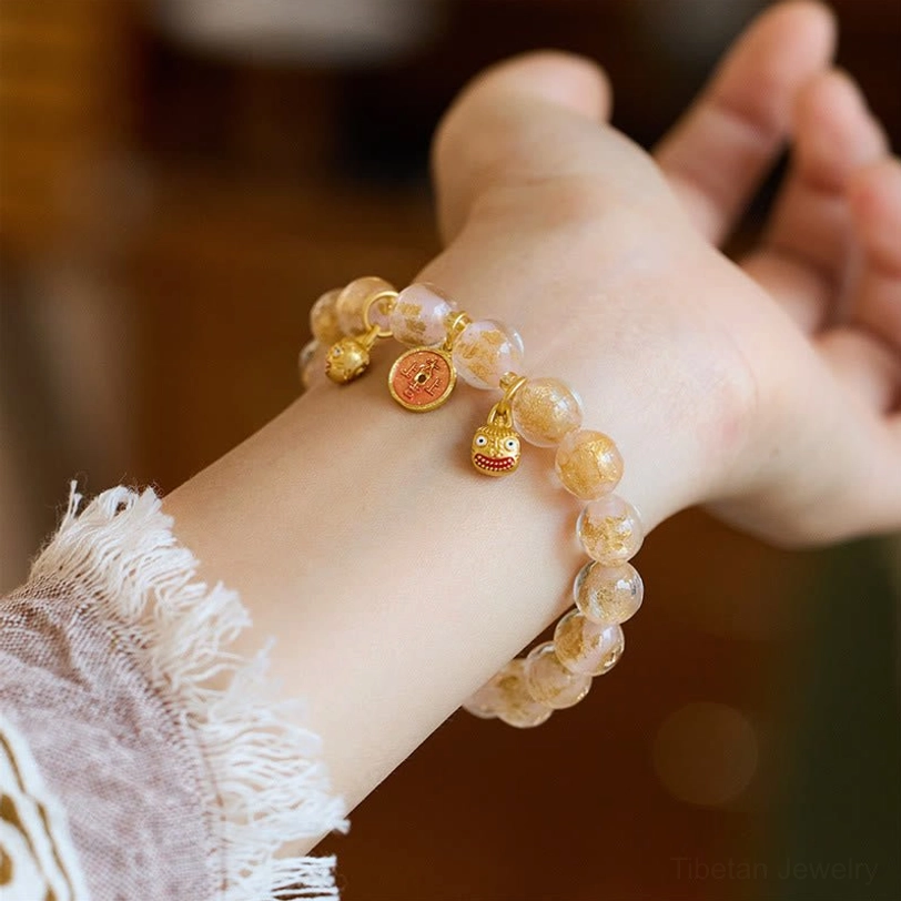 Single light pink liuli glass fortune bracelet with gold Pi Xiu beast charm, side wrist-worn angle