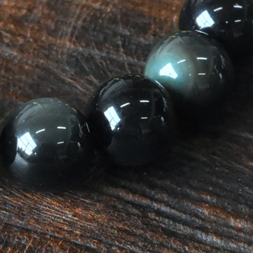Loose Rainbow Obsidian Beads Flat Lay - Deep Black Base with Rainbow Iridescent Luster and Smooth Polished Finish