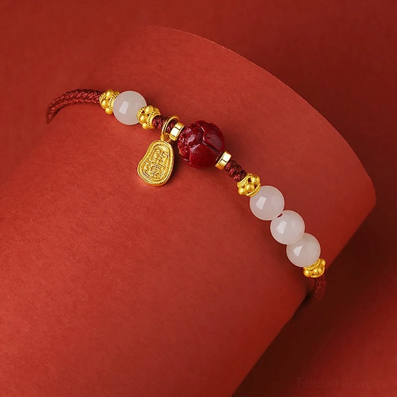 Hetian white jade cinnabar lotus charm bracelet side angle with gold pendant detail