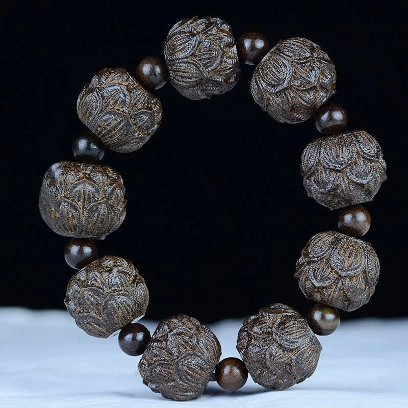 Lotus flower engraved ebony wood bracelet displayed flat showing detailed hand-carved lotus bead designs
