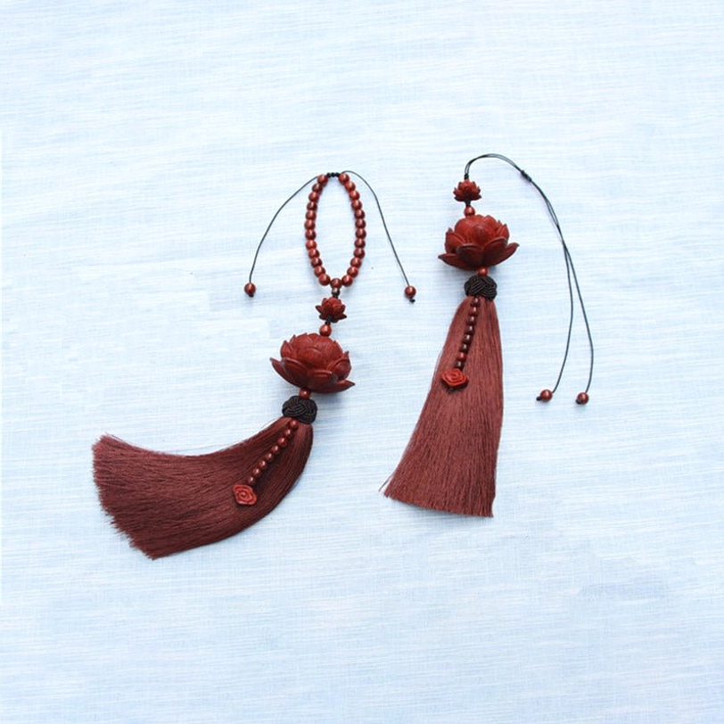 Tibetan red sandalwood lotus charm bracelet detail shot showing hand-carved wooden lotus and beaded string construction