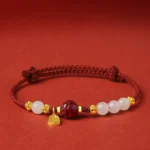 24K gold plated lotus cinnabar white jade red string bracelet front view flat lay