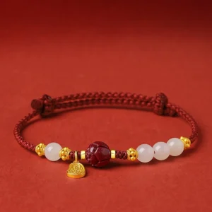 24K gold plated lotus cinnabar white jade red string bracelet front view flat lay