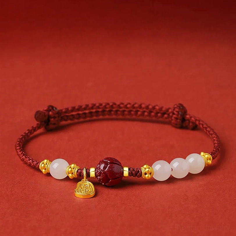 24K gold plated lotus cinnabar white jade red string bracelet front view flat lay