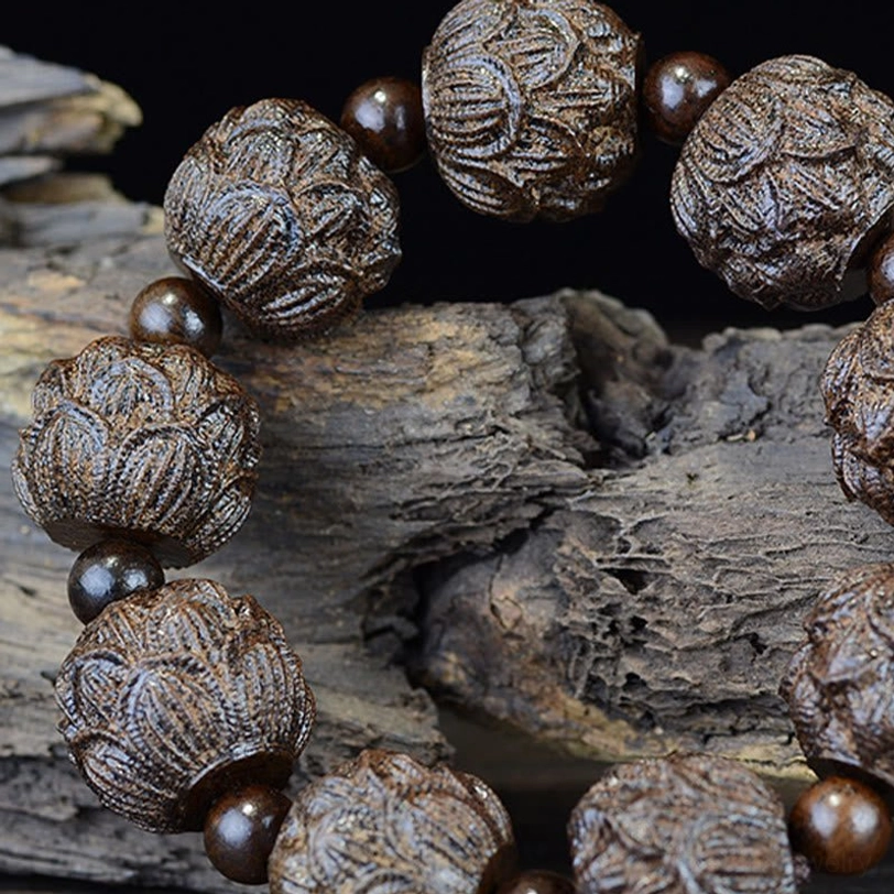 Detailed close-up of lotus carved ebony wood bracelet bead showing 3D lotus flower carving on natural wood