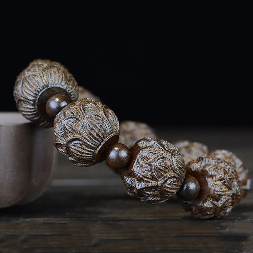 Close-up side angle view of lotus carved ebony wood bracelet showing intricate 3D lotus carving details