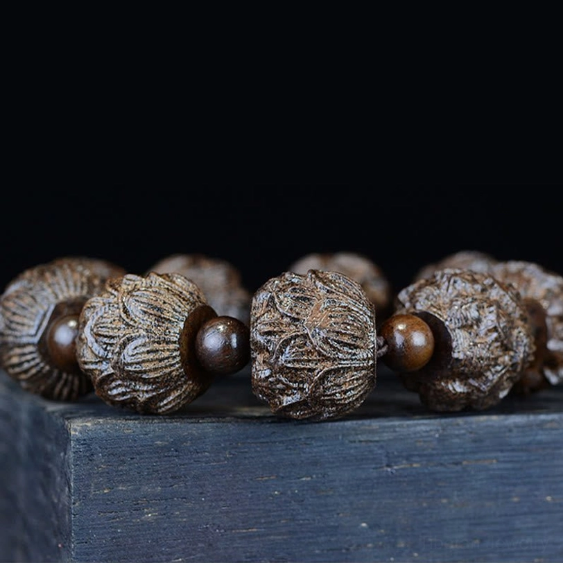 Multiple lotus carved ebony wood bracelets side by side showing hand-carved lotus patterns and dark brown finish